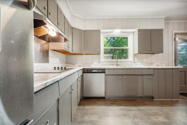 kitchen with stainless steel appliances, a healthy amount of sunlight, hardwood / wood-style flooring, and sink