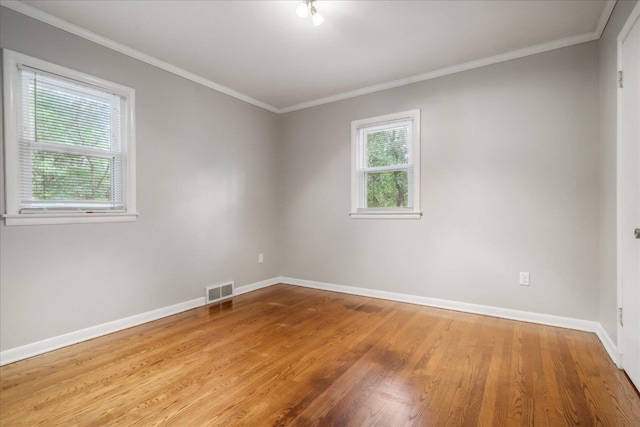 unfurnished room featuring ornamental molding and light hardwood / wood-style flooring