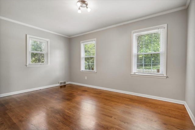 unfurnished room with hardwood / wood-style flooring and crown molding