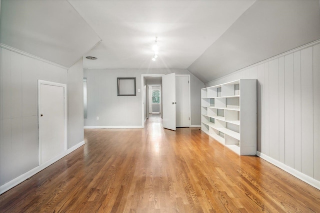 bonus room with vaulted ceiling and light wood-type flooring