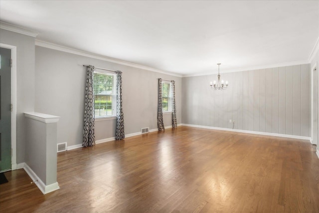 unfurnished room with crown molding, an inviting chandelier, and dark hardwood / wood-style flooring