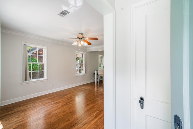 empty room featuring ornamental molding, wood-type flooring, and ceiling fan