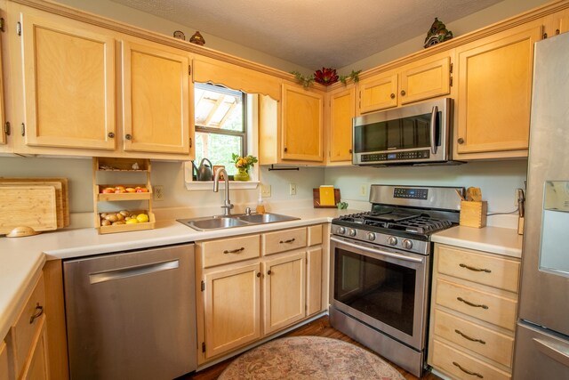 kitchen featuring light brown cabinets, hardwood / wood-style floors, stainless steel appliances, a textured ceiling, and sink