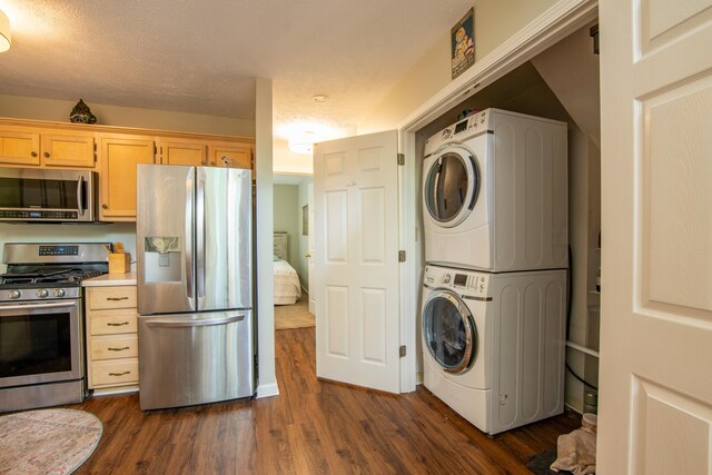 clothes washing area with stacked washer and dryer and dark wood-type flooring