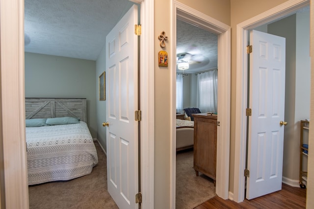 hall with a textured ceiling and carpet floors