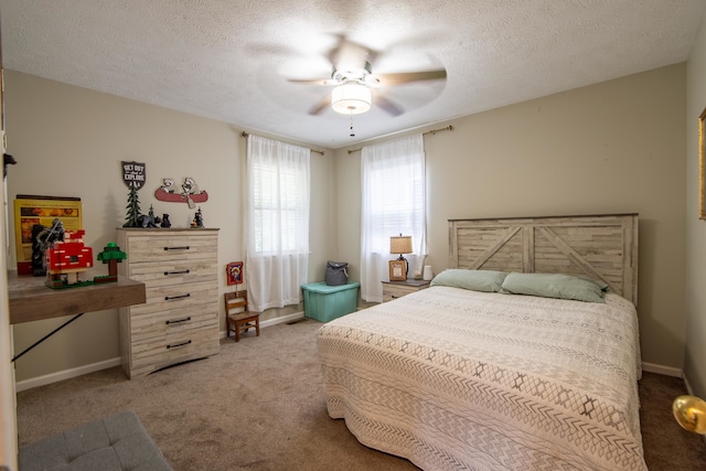 bedroom with ceiling fan, carpet floors, and a textured ceiling