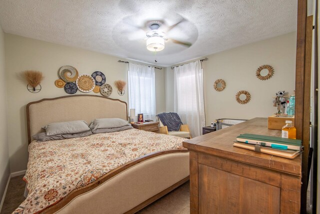 carpeted bedroom with ceiling fan and a textured ceiling