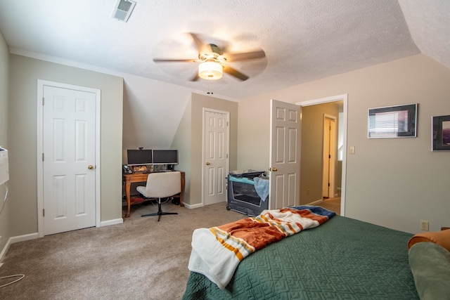 bedroom featuring ceiling fan, vaulted ceiling, a textured ceiling, and carpet flooring