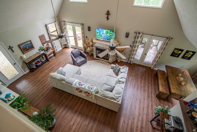 living room featuring a high ceiling, french doors, a wealth of natural light, and wood-type flooring