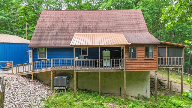 back of property with central AC and a deck