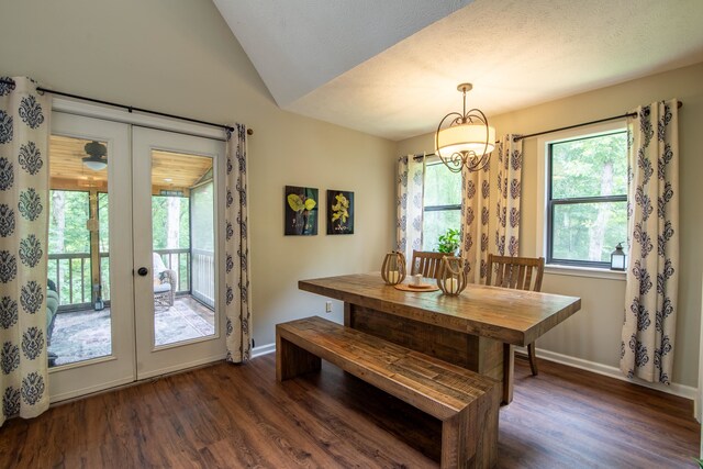 dining space with a notable chandelier, french doors, dark hardwood / wood-style floors, and lofted ceiling