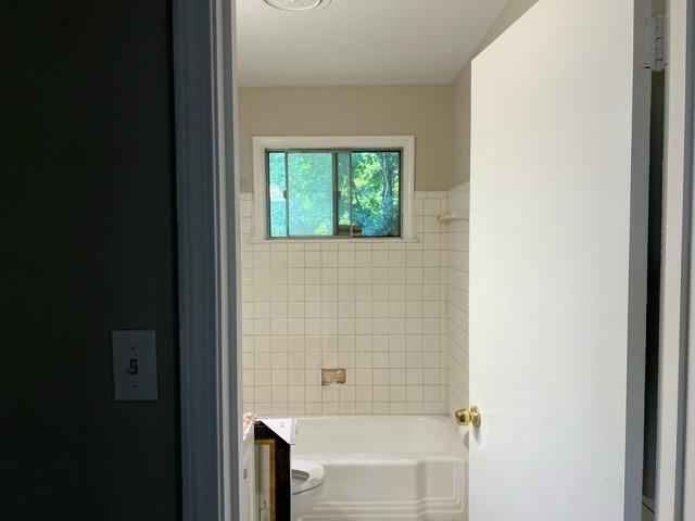 full bathroom with vanity, toilet, and tiled shower / bath combo