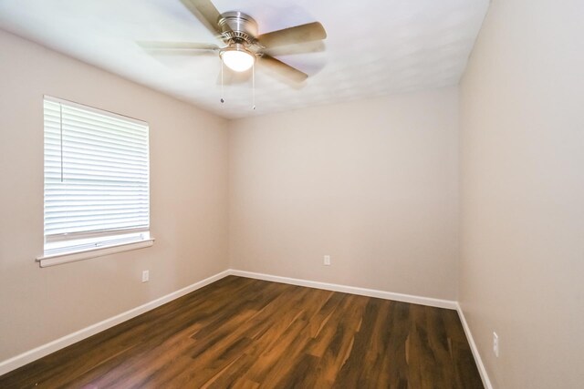 spare room featuring plenty of natural light, ceiling fan, and dark wood-type flooring