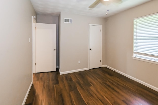 unfurnished bedroom featuring ceiling fan and dark wood-type flooring