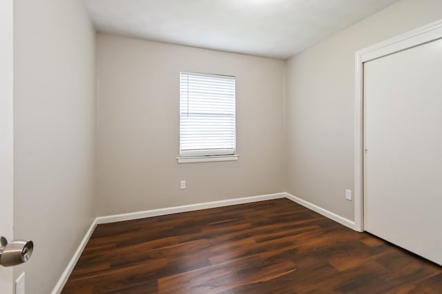 unfurnished room with dark wood-type flooring