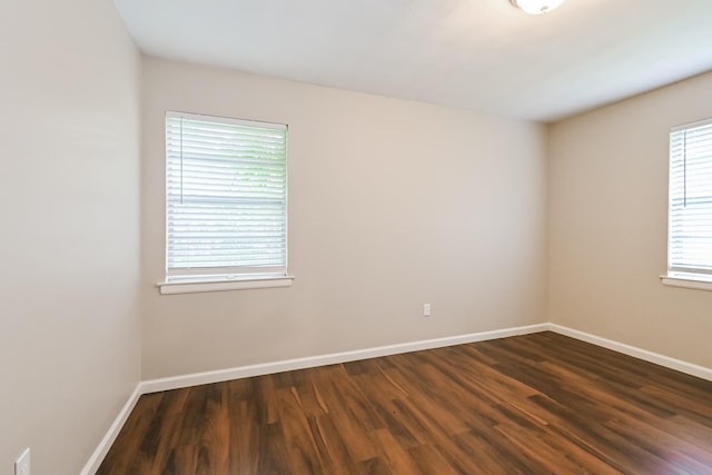 empty room with dark hardwood / wood-style flooring