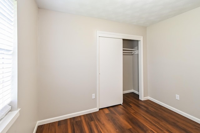 unfurnished bedroom featuring dark hardwood / wood-style floors and a closet