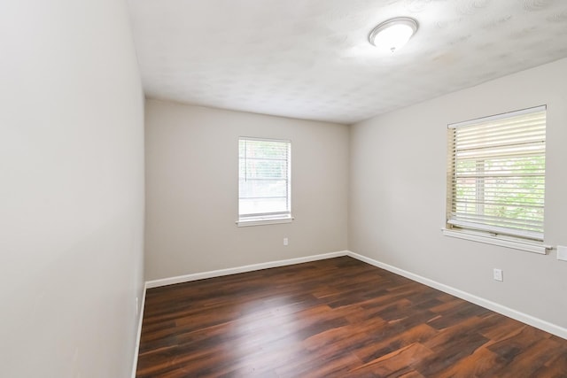 unfurnished room with dark hardwood / wood-style floors