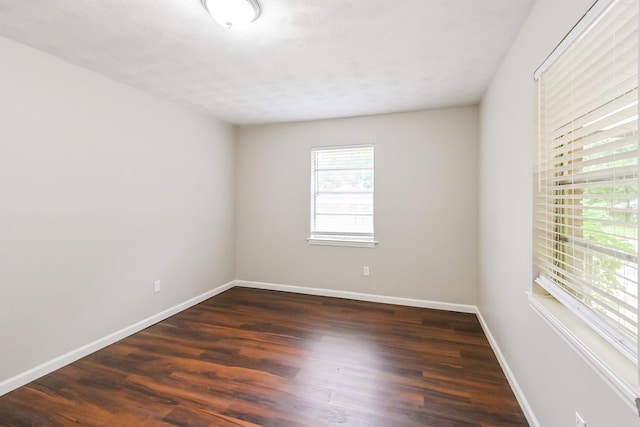 unfurnished room with dark hardwood / wood-style flooring