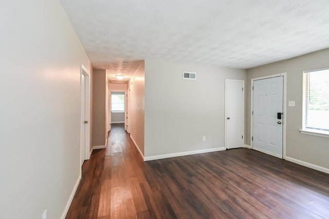 entrance foyer with dark hardwood / wood-style flooring and a healthy amount of sunlight