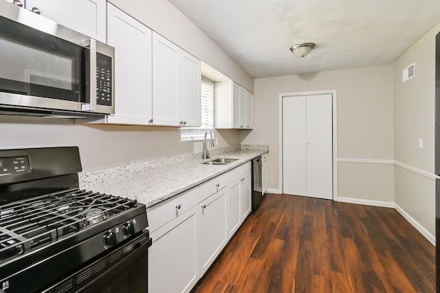 kitchen featuring white cabinetry, sink, light stone counters, dark hardwood / wood-style floors, and black appliances