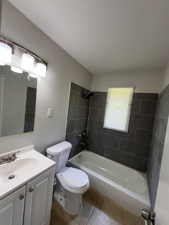 full bathroom featuring tile patterned floors, vanity, a textured ceiling, tiled shower / bath combo, and toilet