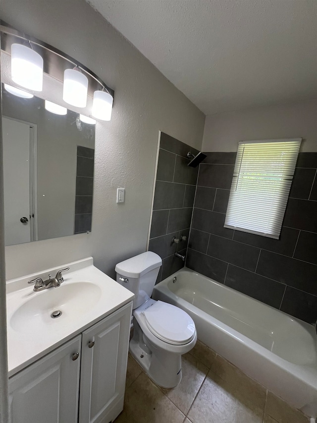 full bathroom featuring vanity, tile patterned floors, tiled shower / bath combo, toilet, and a textured ceiling