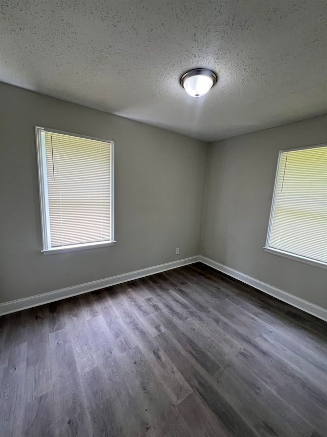 empty room featuring dark hardwood / wood-style flooring and a textured ceiling