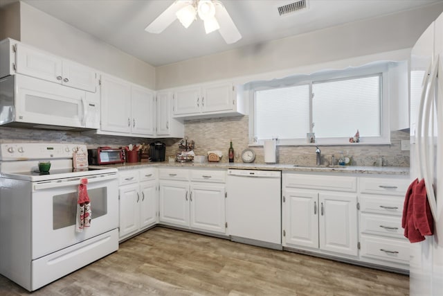 kitchen featuring white cabinetry, sink, backsplash, white appliances, and light wood-type flooring