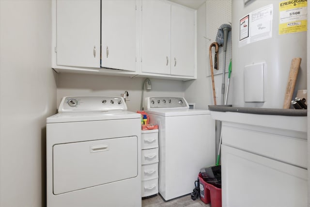 washroom with washer and dryer, cabinets, and water heater