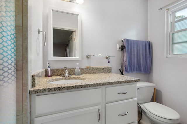 bathroom with vanity, curtained shower, and toilet