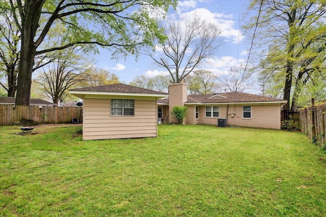 back of property with a lawn and central air condition unit