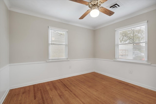 spare room with hardwood / wood-style flooring, ceiling fan, crown molding, and a wealth of natural light