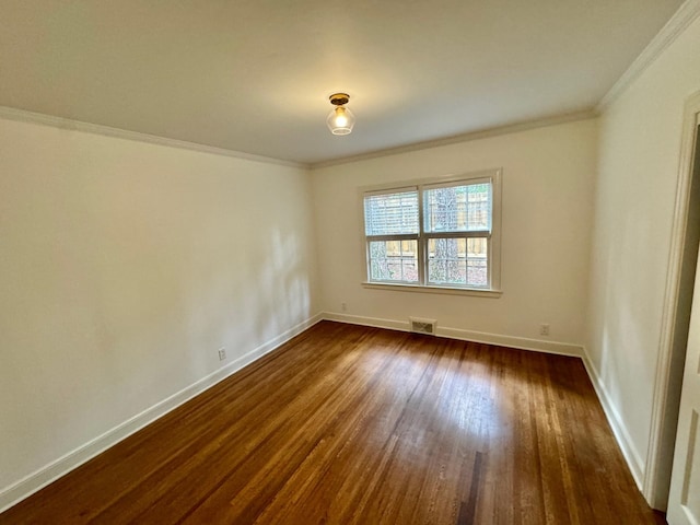 empty room featuring dark hardwood / wood-style floors and ornamental molding