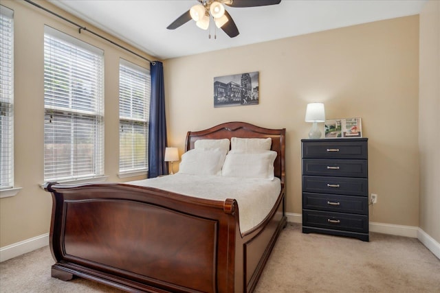 bedroom featuring light carpet, baseboards, and a ceiling fan