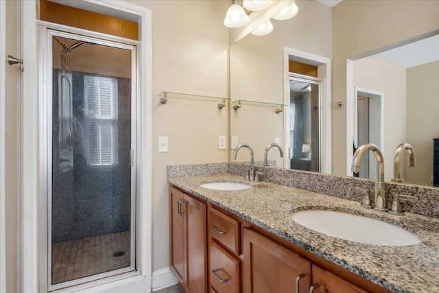 bathroom with a sink, a shower stall, and double vanity