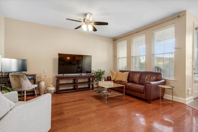 living room featuring ceiling fan, wood finished floors, and baseboards