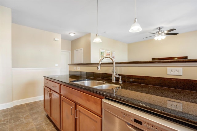 kitchen with brown cabinets, decorative light fixtures, a sink, dishwasher, and baseboards