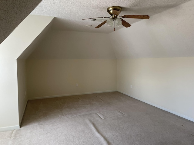 bonus room with ceiling fan, light colored carpet, lofted ceiling, and a textured ceiling