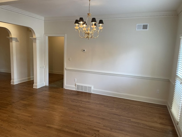 unfurnished room featuring a chandelier, decorative columns, crown molding, and dark wood-type flooring