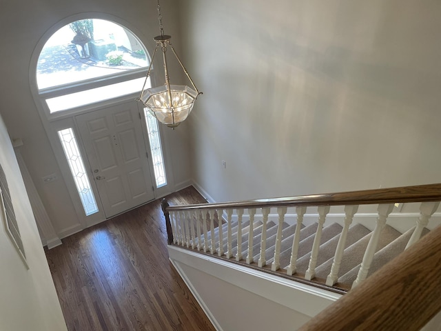 foyer with dark hardwood / wood-style flooring and a chandelier