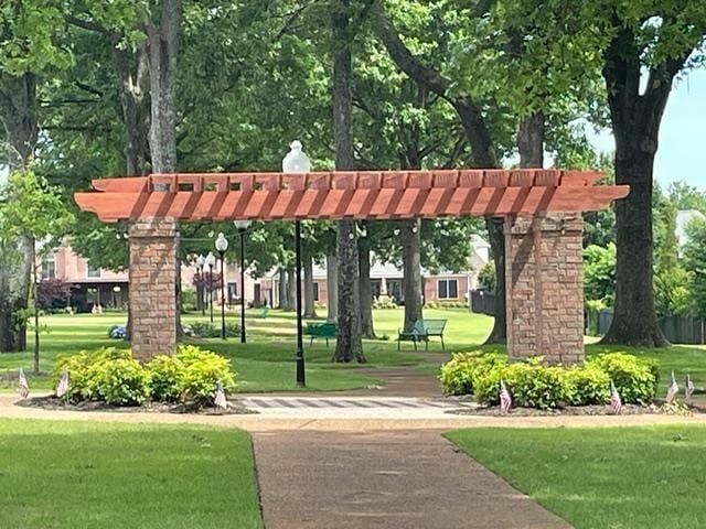 view of community with a pergola and a yard