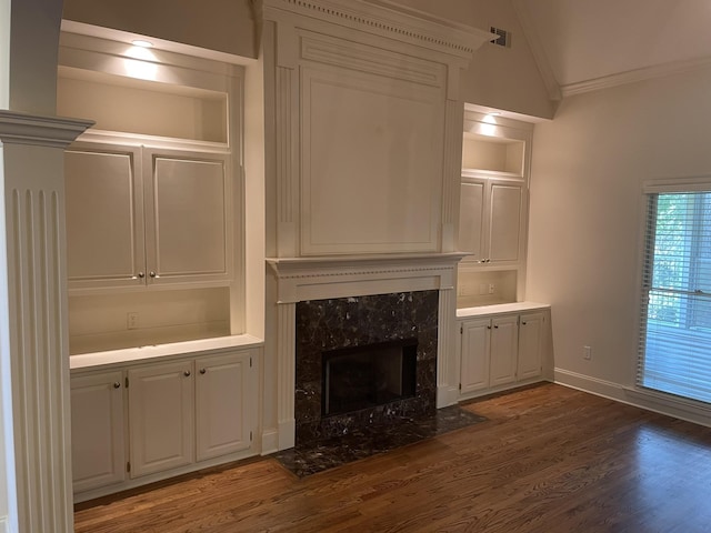 unfurnished living room with a fireplace, dark hardwood / wood-style flooring, vaulted ceiling, and crown molding