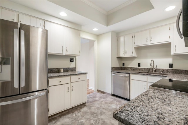 kitchen with white cabinets, stainless steel appliances, dark stone countertops, and sink