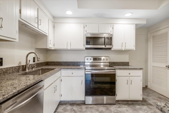 kitchen featuring white cabinets, appliances with stainless steel finishes, stone countertops, and sink