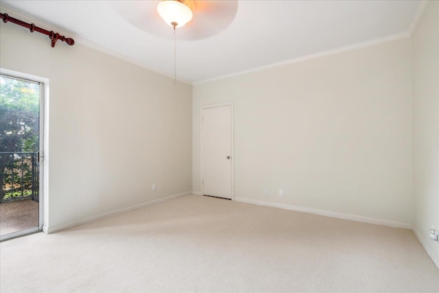 carpeted spare room featuring ceiling fan and crown molding