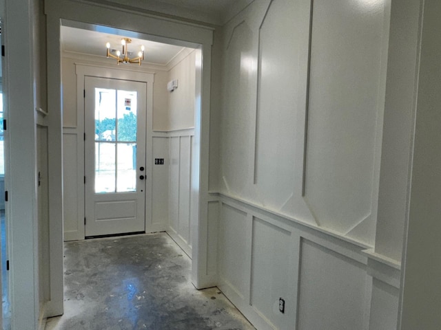 entryway featuring ornamental molding and a chandelier