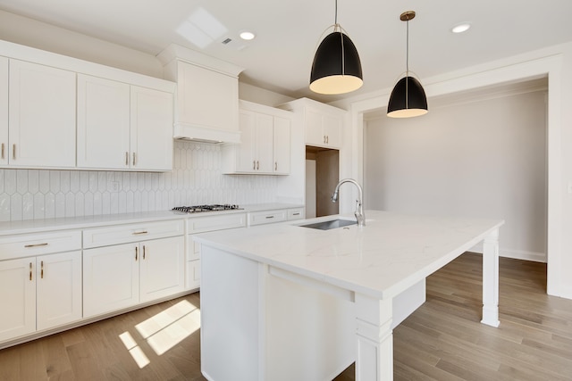 115 Independence Ln, Rossville, TN 38066 - kitchen with gas stovetop, decorative backsplash, white cabinetry, recessed lighting, and an island with sink