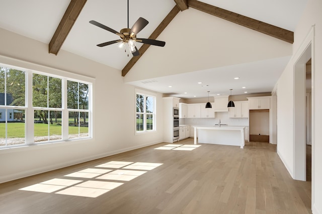 unfurnished living room with beam ceiling, light hardwood / wood-style flooring, high vaulted ceiling, and ceiling fan