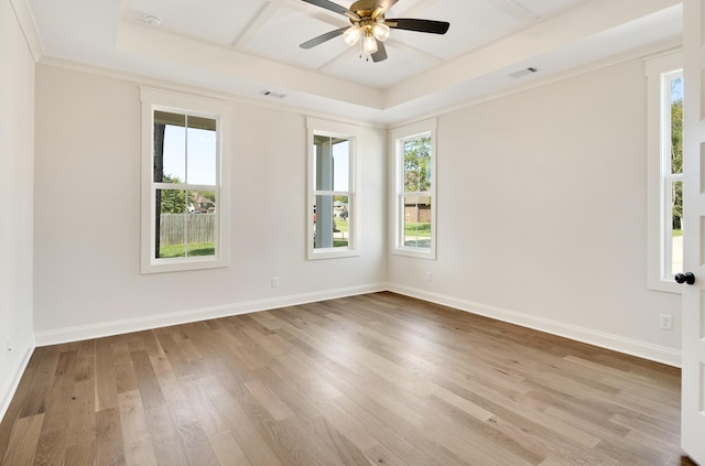 empty room featuring a tray ceiling, ceiling fan, light hardwood / wood-style flooring, and crown molding